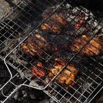 Juicy grilled meat sizzling on an outdoor barbecue for a delicious meal.