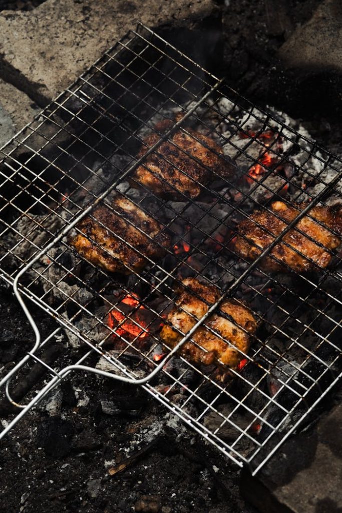 Juicy grilled meat sizzling on an outdoor barbecue for a delicious meal.